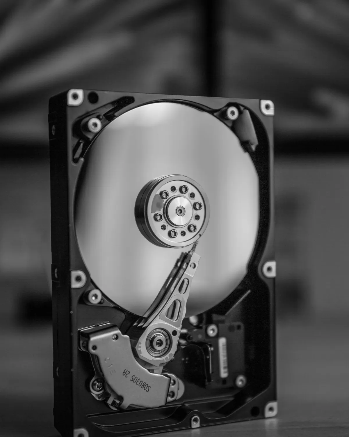 An open hard disk drive showing its platter and actuator arm