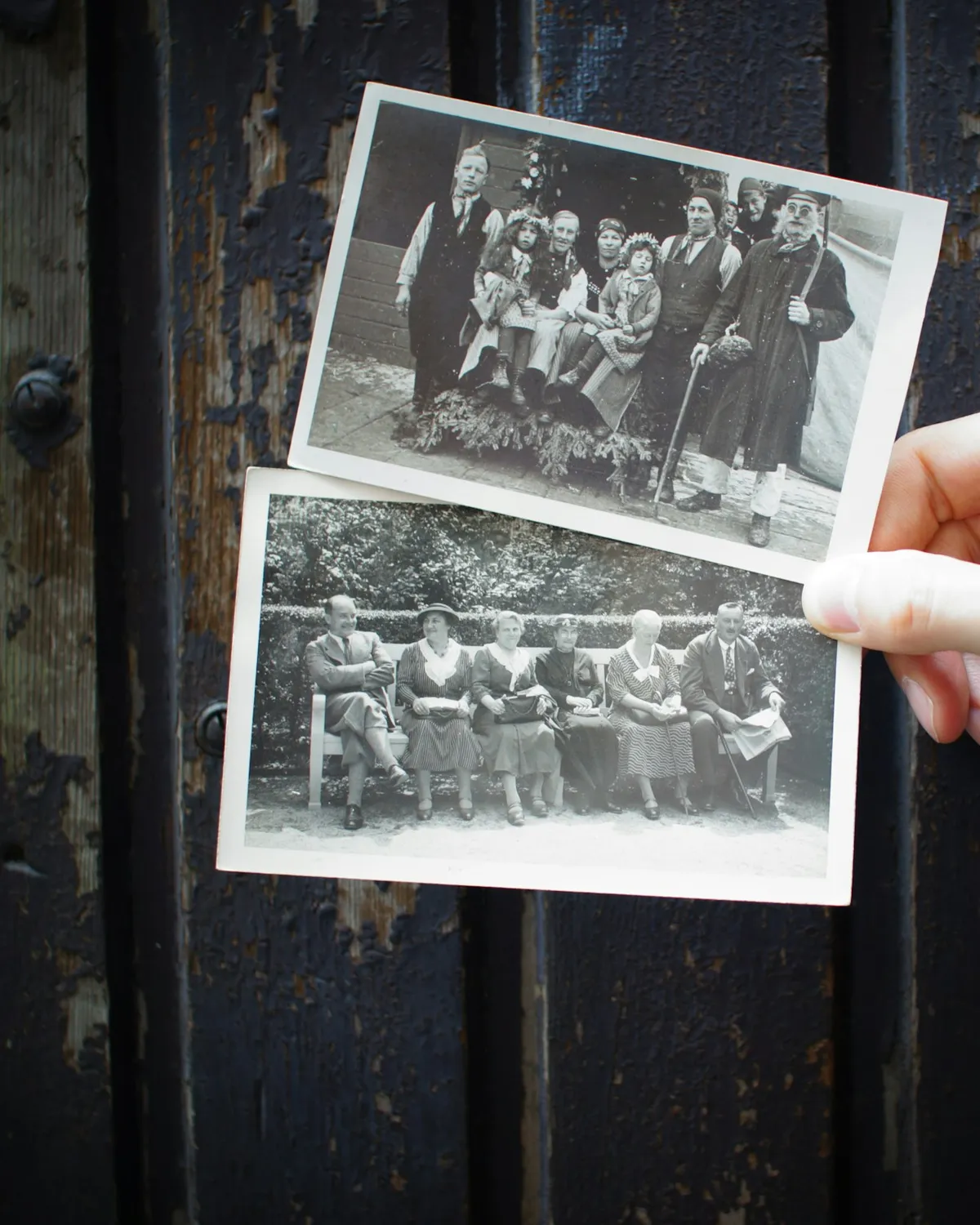 A hand holding two old black-and-white family photographs